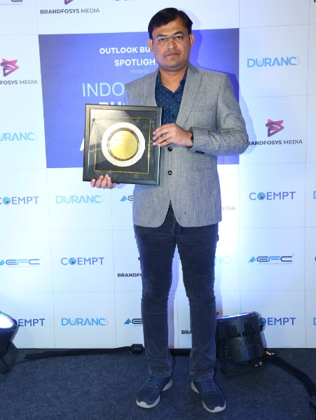 A company head is holding his award in an outlook business event held for excellence in business.